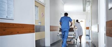 Deux soignant déplace un lit dans le couloir de l'hôpital - MACSF